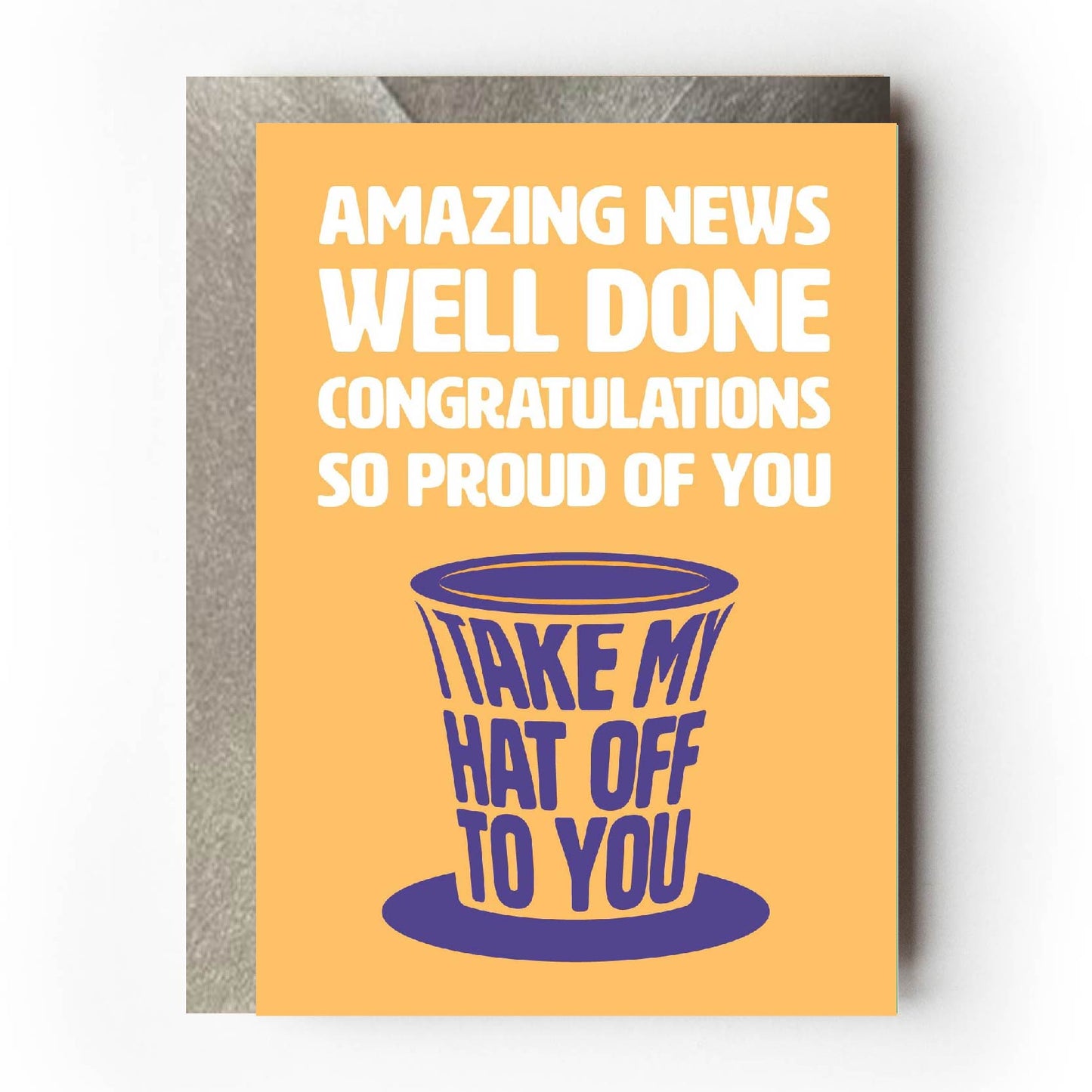Text on card is white and purple against a yellow background and states "Amazing news, well done, congratulations, so proud of you, I take my hat off to you" The text 'I take my hat off to you' is shaped like a top hat" Card measures 105 x 150mm and is supplied with a very striking pewter-effect eco-Kraft envelope.