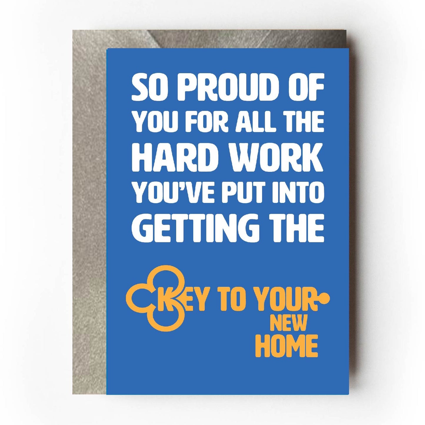 Text on card is white and yellow against a blue background and states "So proud of you for all the hard work you've put into getting the key to your new home" The text which states 'key to your new home' is in the shape of a key Card measures 105 x 150mm and is supplied with a very striking pewter-effect eco-Kraft envelope.