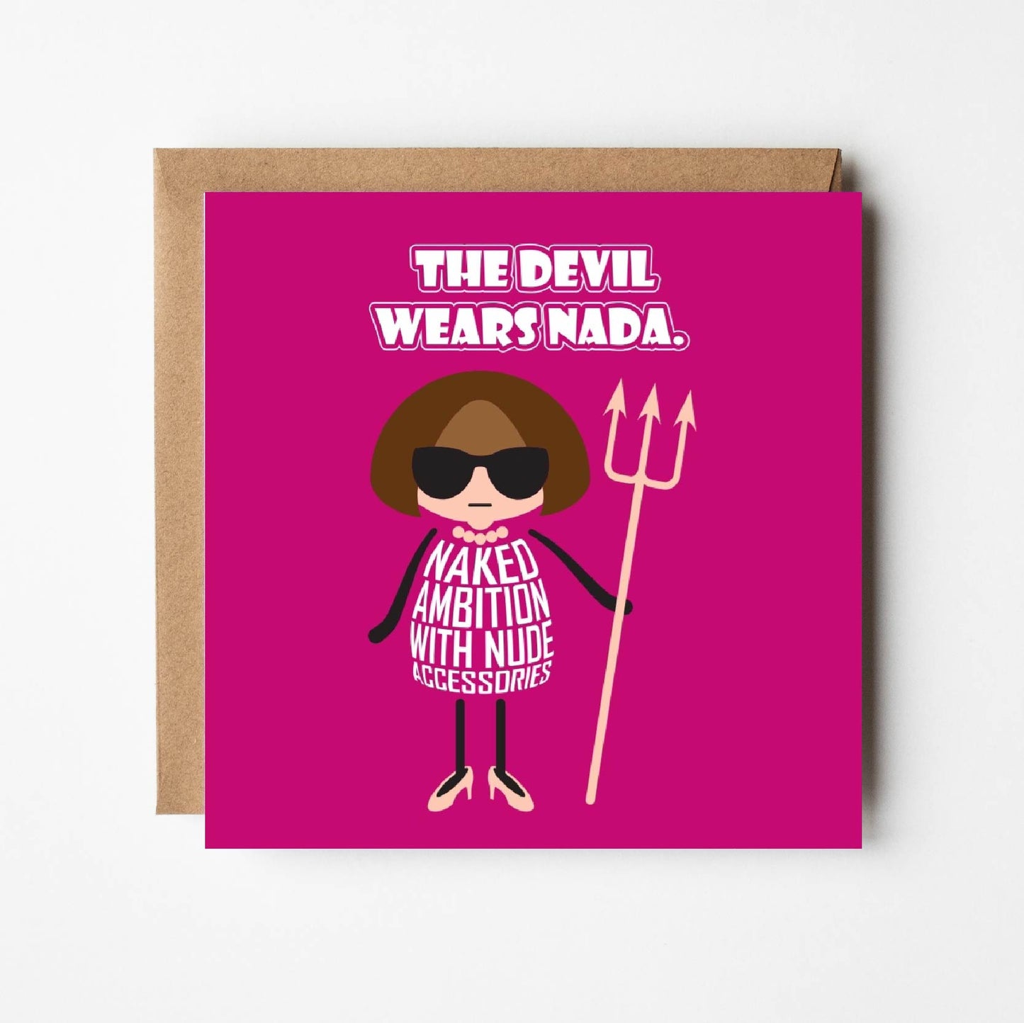 Card titled “Devil wears Nada” in white text on a pink background. A cartoon Anna Wintour wears a nude-coloured necklace, nude shoes and a nude Devil trident. Her dress is made of text which states “Naked ambition with nude accessories”