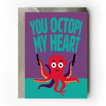 Greeting card with a red octopus and text 'You octopi my heart' on a purple and teal background.