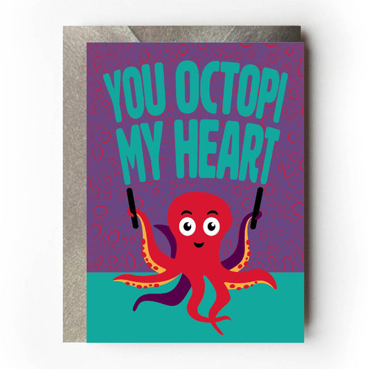 Greeting card with a red octopus and text 'You octopi my heart' on a purple and teal background.