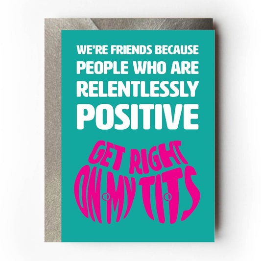 Text on card is white and pink against teal background and states "We're friends because people who are relentlessly positive get right on my tits"  Card measures 105 x 150mm and is supplied with a very striking pewter-effect eco-Kraft envelope.