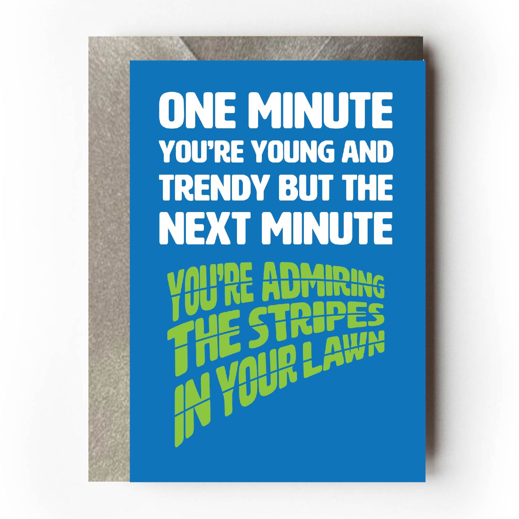 Text on card is white and green against a blue background and states "One minute you're young and trendy but the next minute you're admiring the stripes in your lawn"   Card measures 105 x 150mm and is supplied with a very striking pewter-effect eco-Kraft envelope.