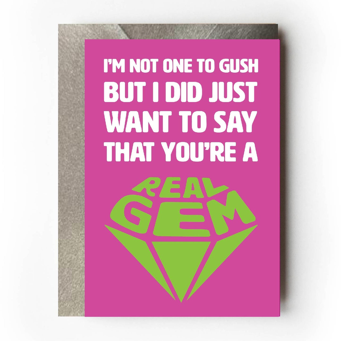 Text on card is white and green against a pink background and states "I'm not one to gush but I did just want to say that you're a real gem"   The text 'real gem' is in the shape of a cut diamond. Card measures 105 x 150mm and is supplied with a very striking pewter-effect eco-Kraft envelope.