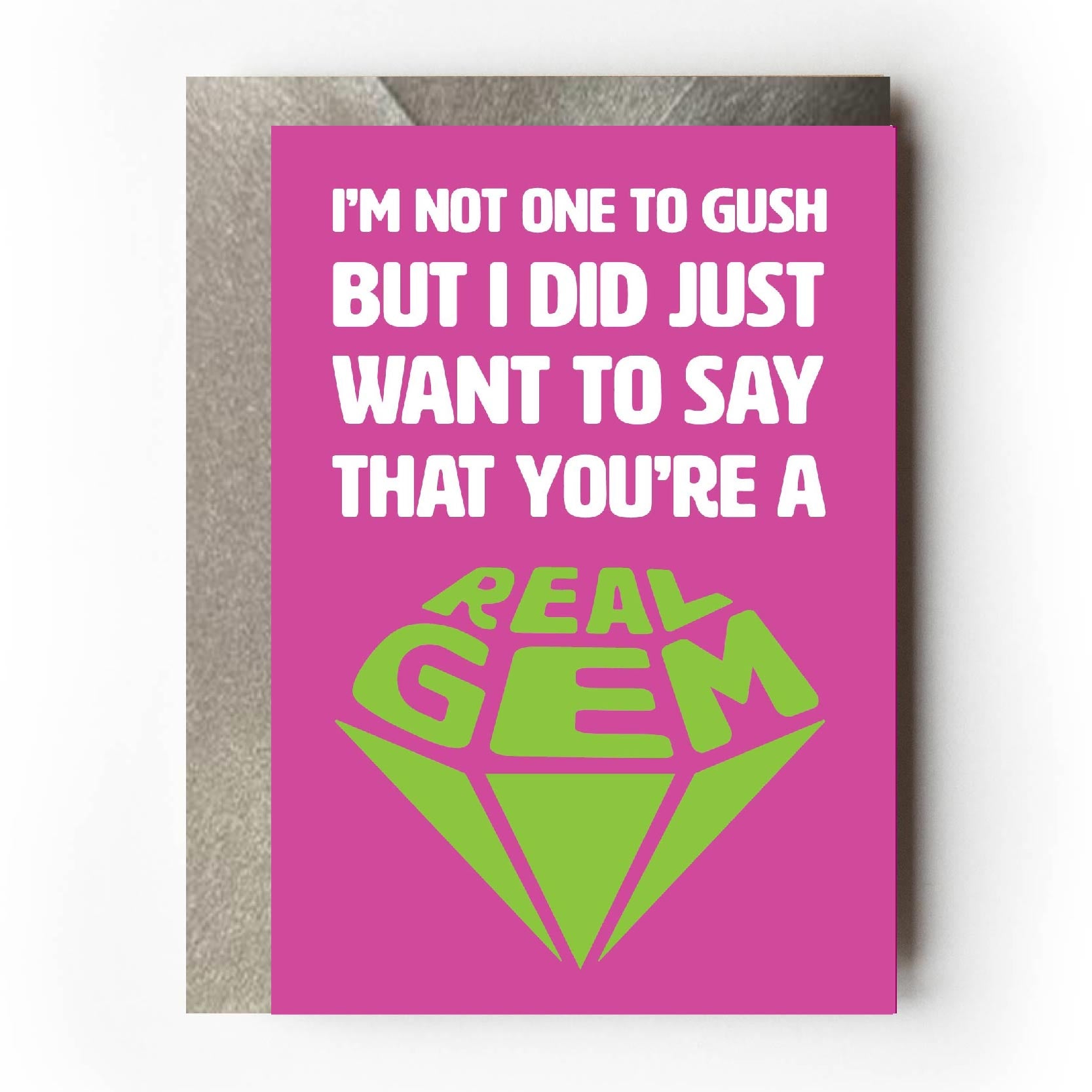 Text on card is white and green against a pink background and states "I'm not one to gush but I did just want to say that you're a real gem"   The text 'real gem' is in the shape of a cut diamond. Card measures 105 x 150mm and is supplied with a very striking pewter-effect eco-Kraft envelope.