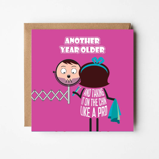 Card text states "Another year older and taking it on the chin like a pro"  Cartoon lady is horrified to see chin hairs in the bathroom but is prepared with tweezers