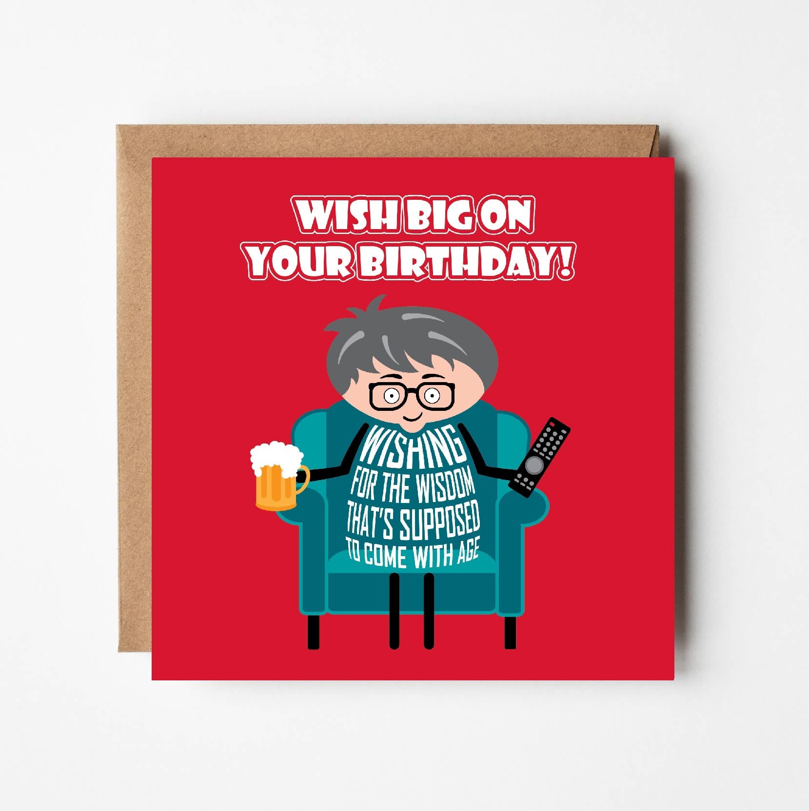 Card titled “Wish big on your birthday!” in white text on red background.  A cartoon man sits in armchair with a beer. His shirt says “Wishing for the wisdom that's supposed to come with age”  Card is 150mm square with a eco-Kraft envelope. 