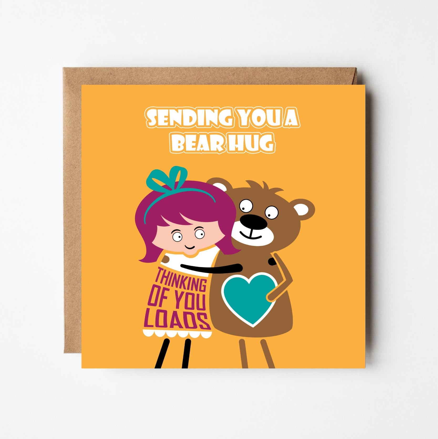 Cute bear hug thinking of you card — cartoon illustration of a girl hugging a bear on a yellow background. 150mm square card shown with recycled Kraft envelope.