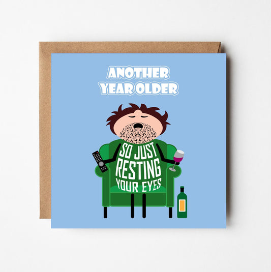 Birthday card for him with cartoon character asleep in armchair.  Text says 'Another year older...so just resting your eyes' on a blue background.