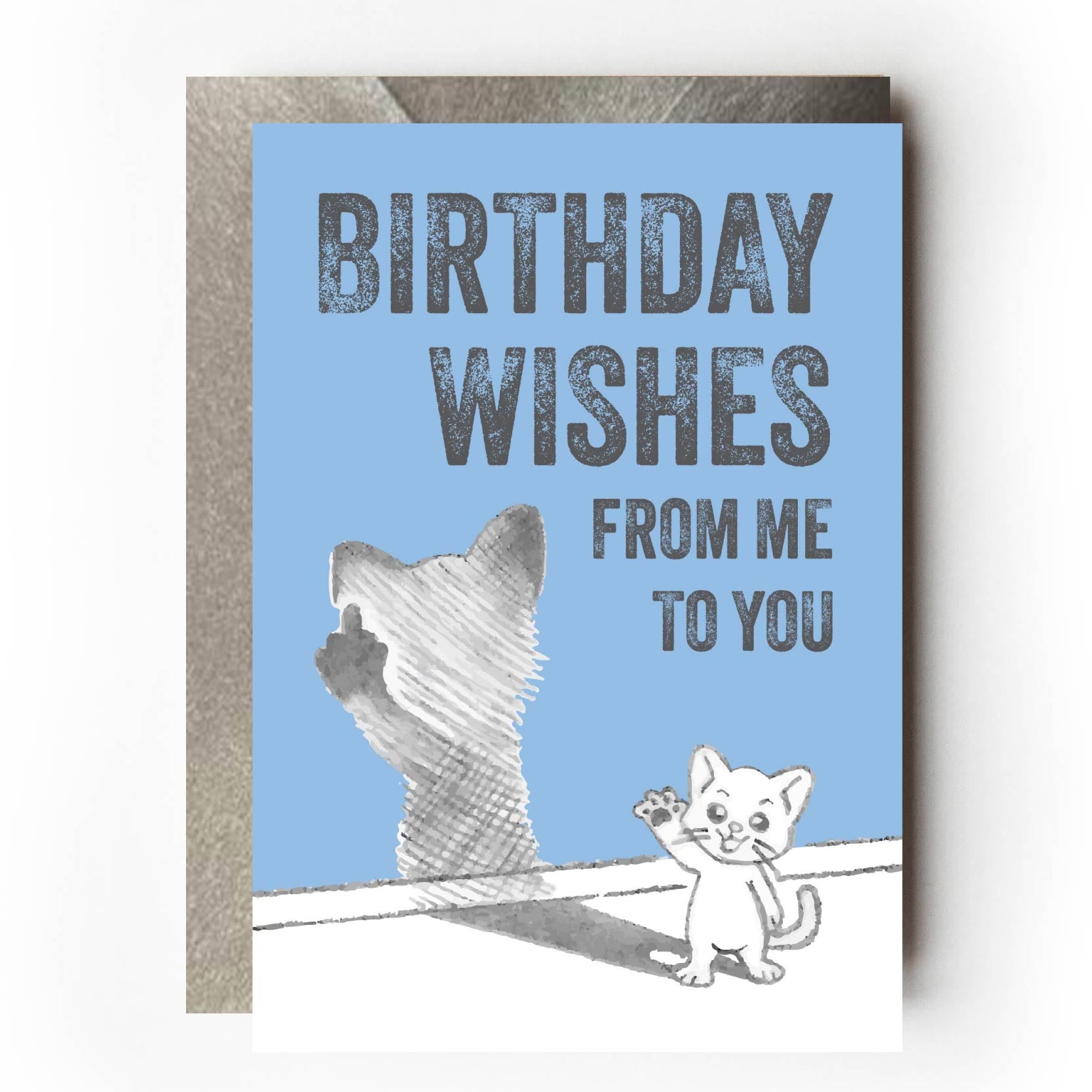 Happy cat waving at you while its shadow is flicking the bird and giving the one finger salute. Text reads: “Birthday wishes from me to you” Funny sarcastic birthday card design for cat lovers.